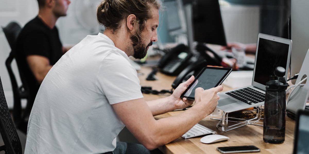 im001 Picture of man looking at an iPad at his desk.