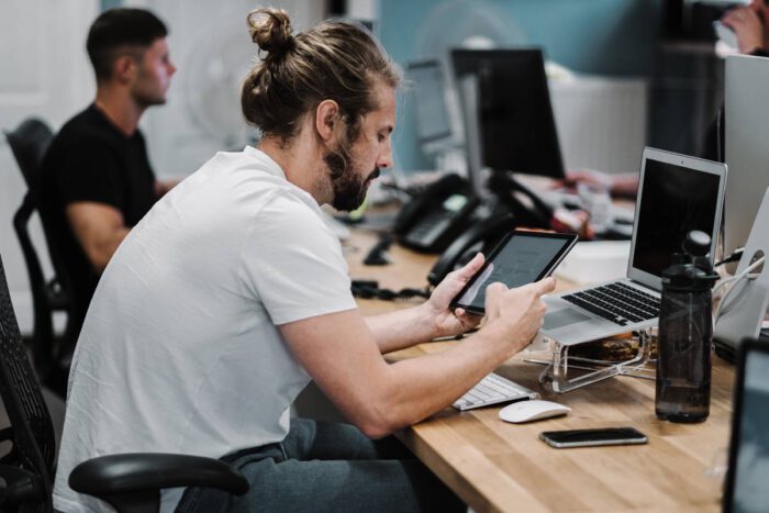 Picture of man looking at an iPad at his desk.